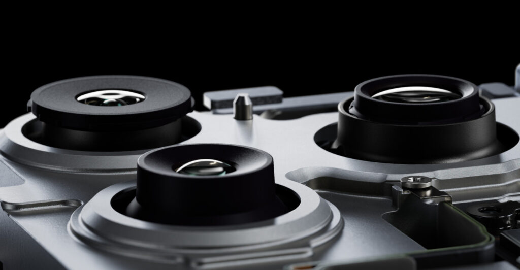 Geöffnetes Smartphone mit drei sichtbaren Kameralinsen und Technik im Inneren